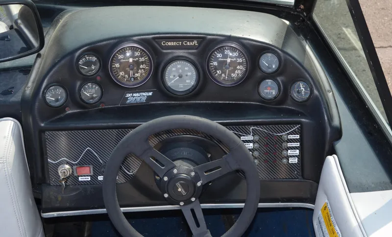 Slide: The Image of 1989 Correct Craft Ski Nautique dashboard with gauges and steering wheel. - 6