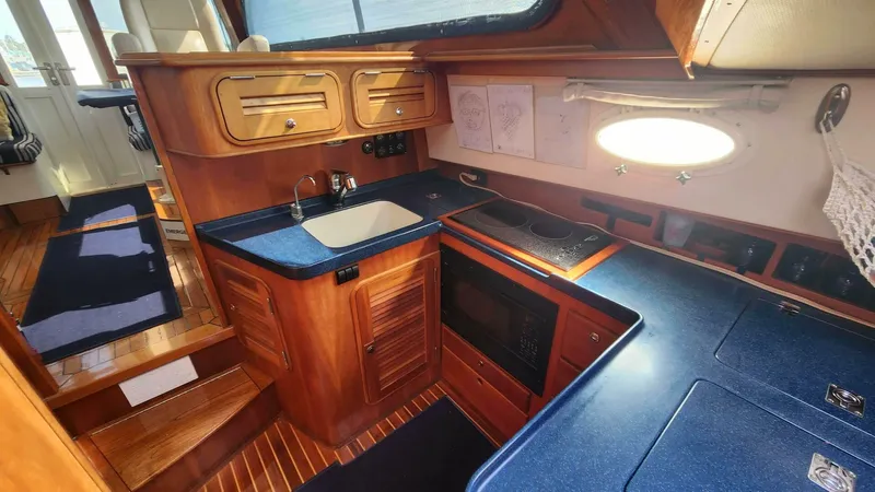 Slide: The Image of Hinckley Talaria 44 FB 2002 yacht interior with wooden cabinetry and modern kitchen amenities. - 11