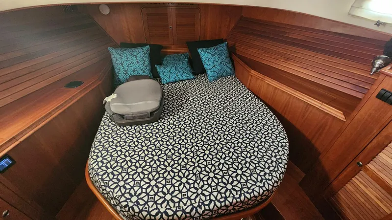 Slide: The Image of Hinckley Talaria 44 FB 2002 cabin with patterned bedding and wooden interior. - 13