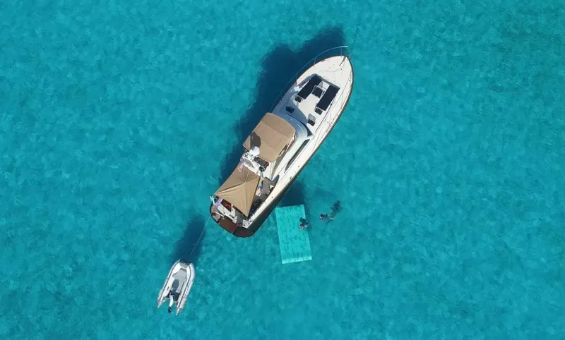 Slide: The Image of Hinckley Talaria 44 FB 2002 yacht on clear turquoise water, aerial view. - 3