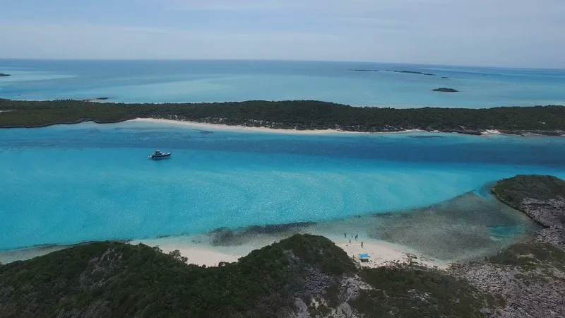 Slide: The Image of Hinckley Talaria 44 FB yacht cruising in turquoise waters near lush islands, 2002 model. - 4