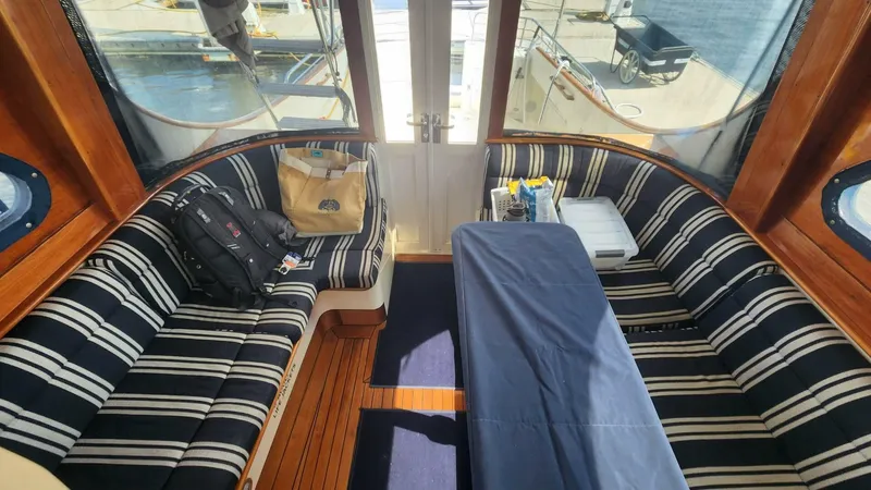 Slide: The Image of Interior of 2002 Hinckley Talaria 44 FB with striped seating and wooden flooring. - 9