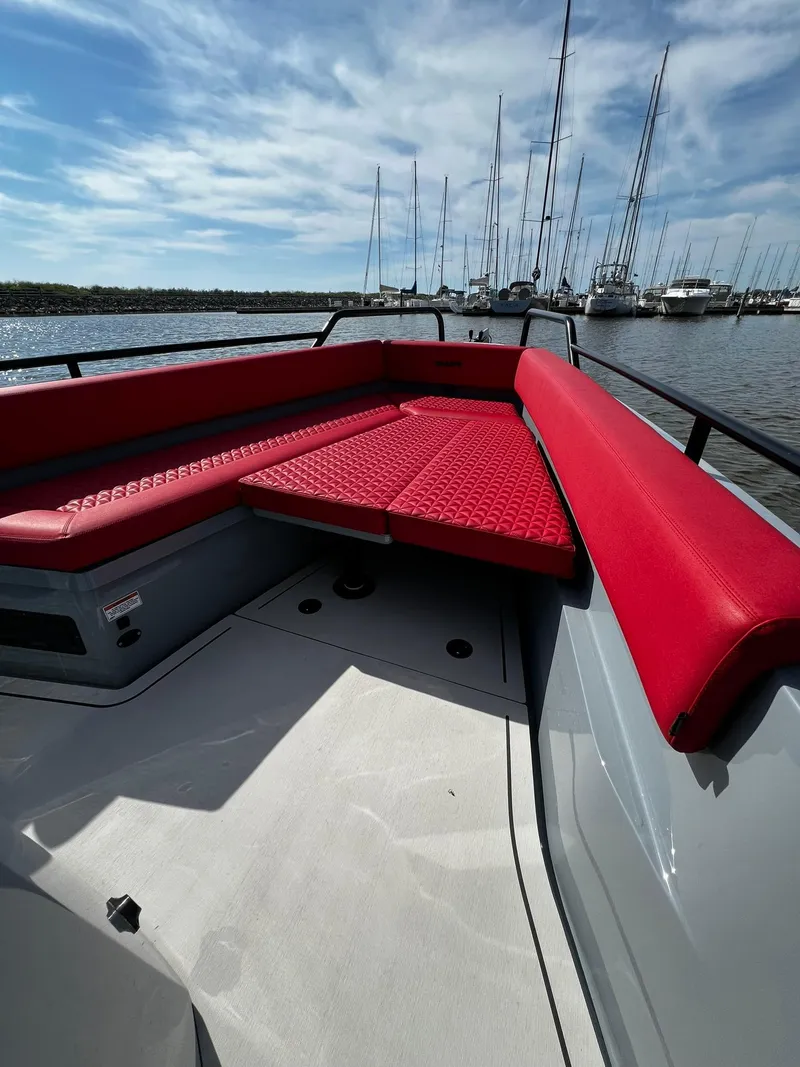 Slide: The Image of 2022 BRABUS Shadow 500 Cabin with red seating, docked in a marina under a blue sky. - 17