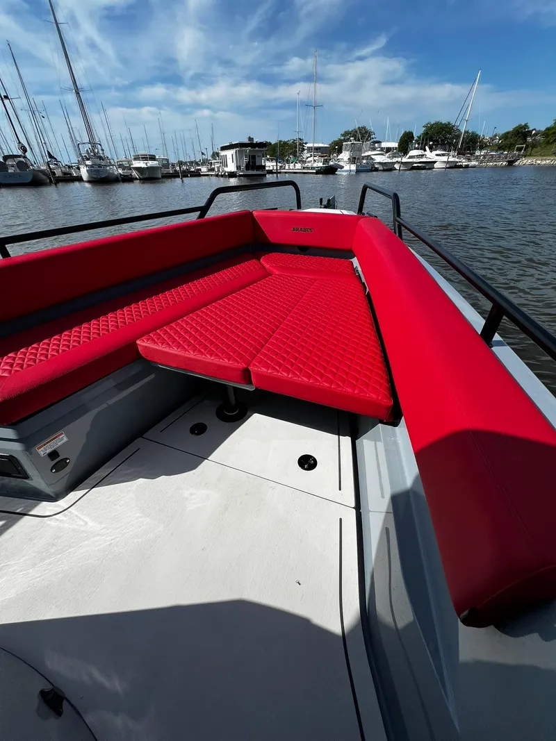 Slide: The Image of 2022 BRABUS Shadow 500 Cabin with red seating, docked in a marina. - 18