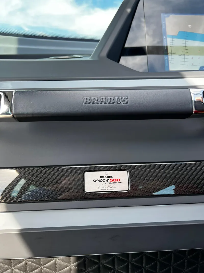 Slide: The Image of 2022 BRABUS Shadow 500 Cabin interior with carbon fiber accents and navigation display. - 32
