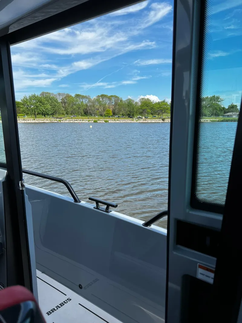 Slide: The Image of 2022 BRABUS Shadow 500 Cabin boat view, serene waters, lush green shoreline, blue sky. - 37