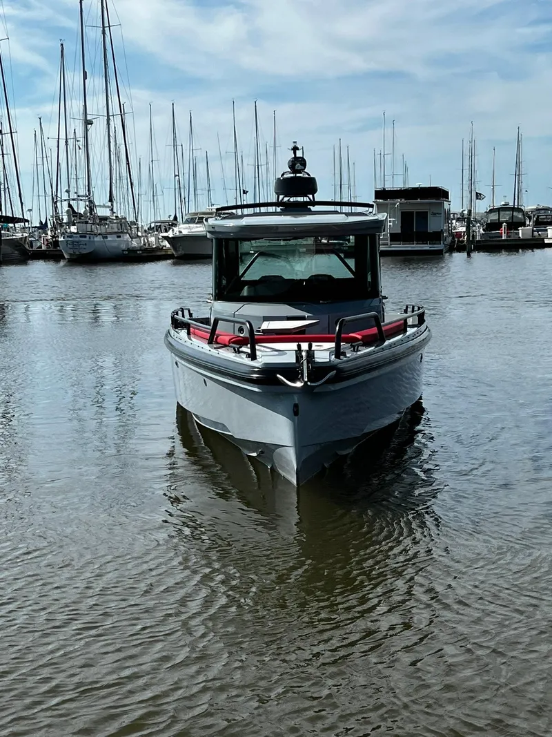 Slide: The Image of 2022 BRABUS Shadow 500 Cabin boat docked in a marina, surrounded by sailboats. - 4