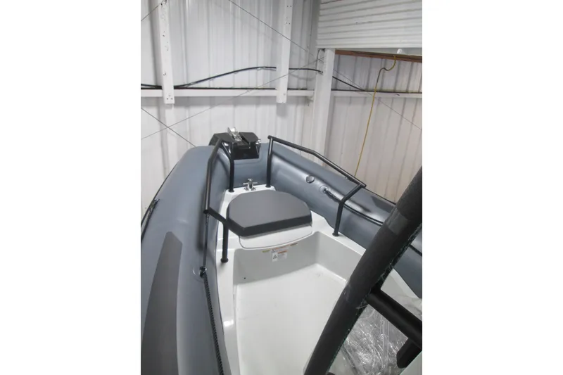 Slide: The Image of 2025 Zodiac Pro 6.5 boat interior with seating and control panel in a storage facility. - 12