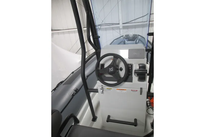 Slide: The Image of 2025 Zodiac Pro 6.5 boat cockpit with steering wheel and control panel. - 14