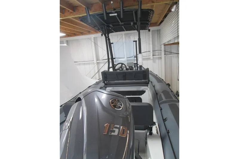 Slide: The Image of 2025 Zodiac Pro 6.5 boat with Yamaha 150 engine in a storage facility. - 2