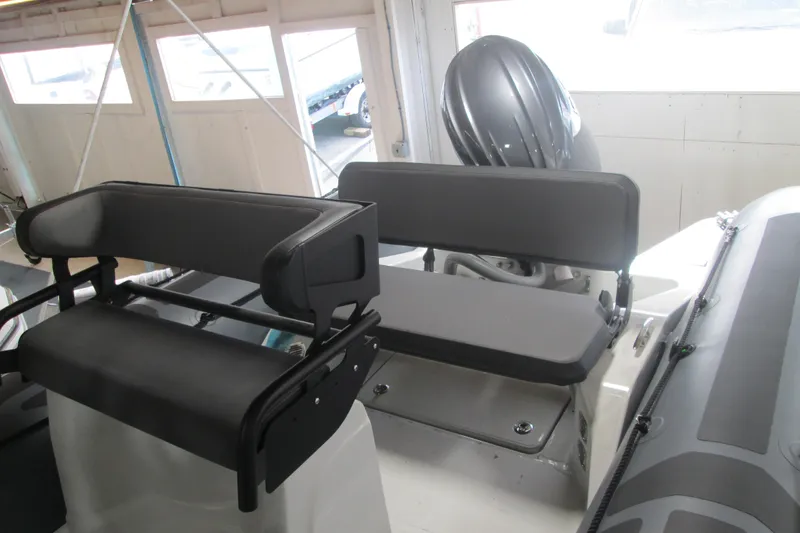 Slide: The Image of 2025 Zodiac Pro 6.5 boat interior with seating and motor in a showroom. - 7