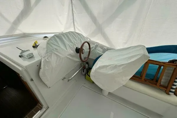 Slide: The Image of 2002 Luhrs 38 Open boat helm with protective covers and wooden accents. - 13