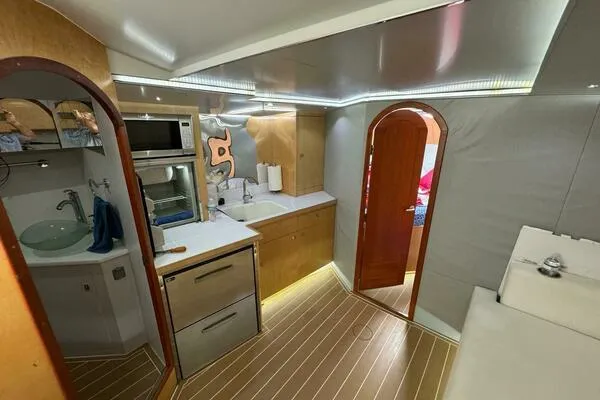 Slide: The Image of 2002 Luhrs 38 Open yacht interior with modern kitchen and wood flooring. - 16