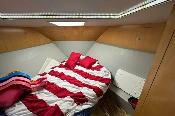 Slide: The Image of 2002 Luhrs 38 Open cabin with striped bedding and wooden interior. - 18