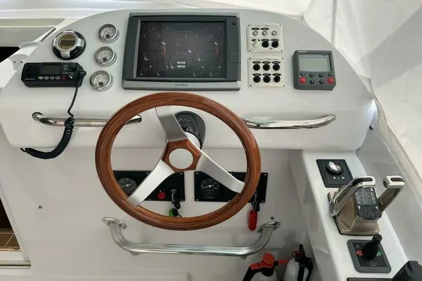 Slide: The Image of Control panel of a 2002 Luhrs 38 Open boat with steering wheel and navigation instruments. - 2
