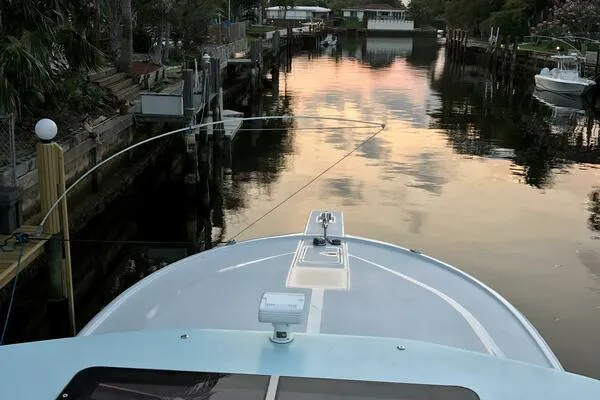 Slide: The Image of Bow view of 2002 Luhrs 38 Open boat on a tranquil waterway at sunset. - 5