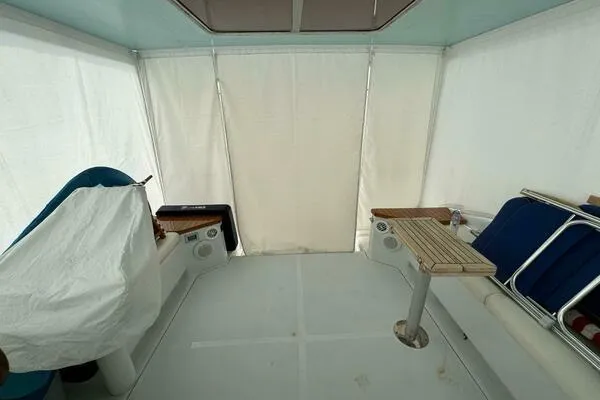 Slide: The Image of 2002 Luhrs 38 Open boat interior with seating and table, enclosed by white curtains. - 9