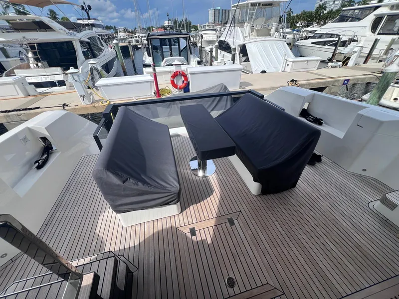 Slide: The Image of 2024 Astondoa AS5 yacht deck with covered seating, docked at a marina. - 10