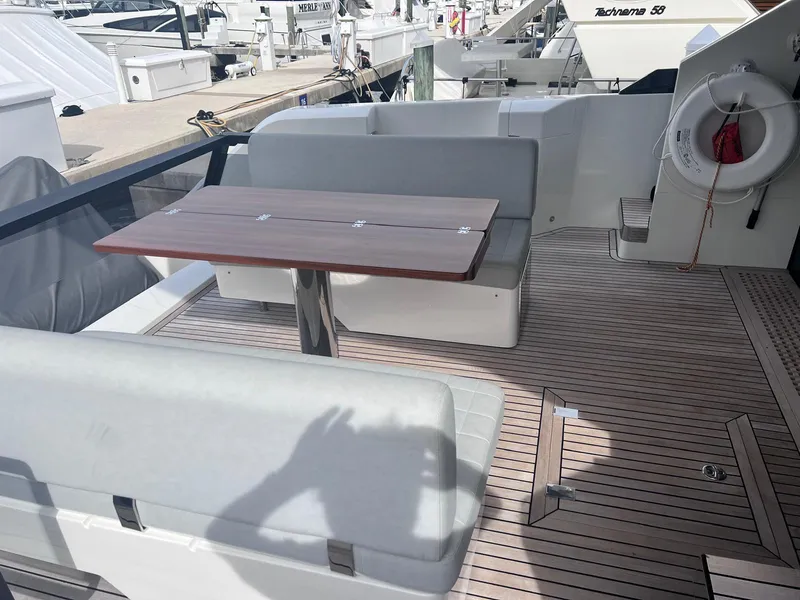 Slide: The Image of 2024 Astondoa AS5 yacht deck with seating and wooden table. - 12
