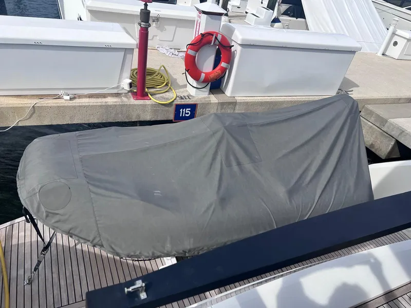 Slide: The Image of Covered Astondoa AS5 yacht at dock, 2024 model, with life preserver nearby. - 13