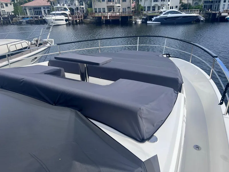 Slide: The Image of 2024 Astondoa AS5 yacht with covered deck seating, docked near waterfront homes. - 6