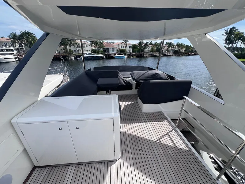 Slide: The Image of 2024 Astondoa AS5 yacht deck with seating, overlooking waterfront homes and palm trees. - 7
