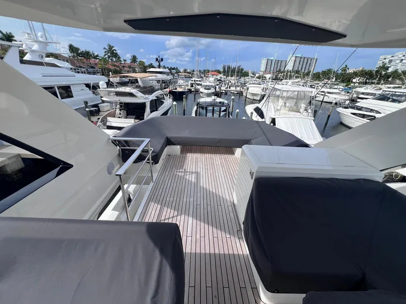Slide: The Image of 2024 Astondoa AS5 yacht deck with marina view, featuring sleek design and luxury seating. - 9