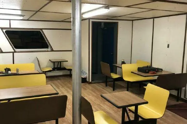 Slide: The Image of Interior of AlumaCat 100, 2000 model, with yellow seating and wooden tables. - 10