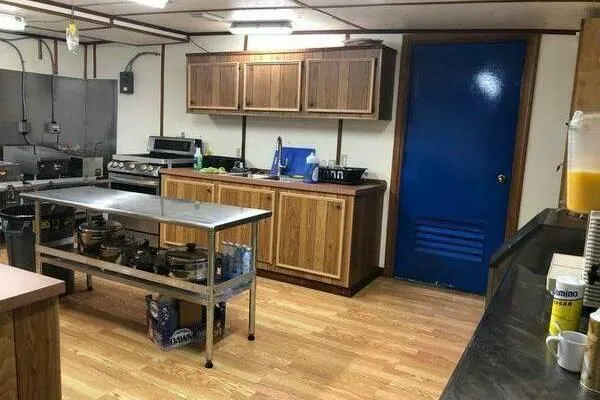 Slide: The Image of Commercial kitchen with wooden cabinets, stainless steel table, and blue door, AlumaCat 100, 2000. - 13