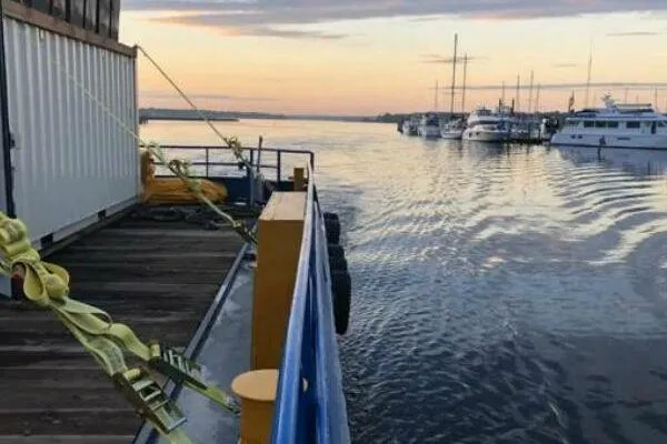 Slide: The Image of AlumaCat 100 boat docked at sunset, 2000 model, with yachts in the background. - 20