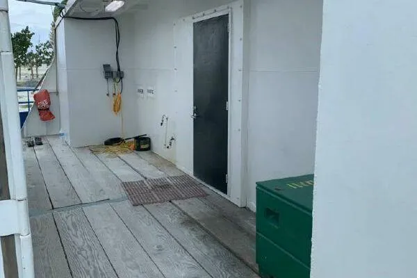 Slide: The Image of AlumaCat 100 boat deck, 2000 model, featuring a black door and safety equipment. - 27