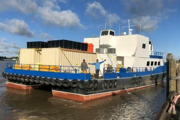 Slide: The Image of AlumaCat 100 vessel from 2000 docked, featuring cargo containers and crew on deck. - 5