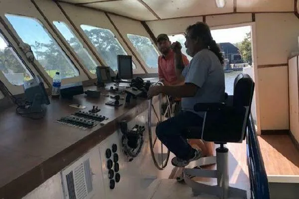 Slide: The Image of Two people in AlumaCat 100 boat cockpit, 2000 model, navigating controls. - 8