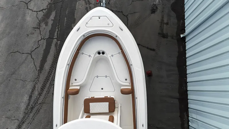 Slide: The Image of 2024 Pioneer 222 Islander boat, aerial view, docked beside a blue building. - 6