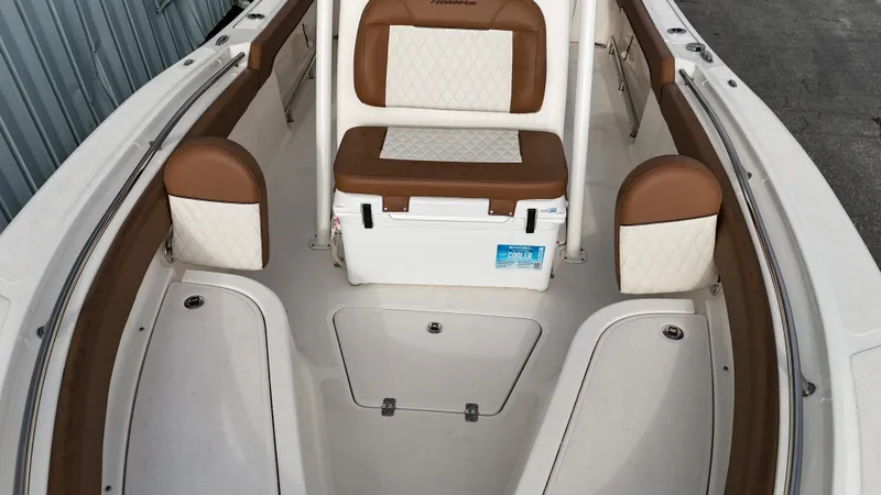 Slide: The Image of 2024 Pioneer 222 Islander boat interior with brown and white seating. - 11