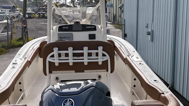 Slide: The Image of 2024 Pioneer 222 Islander boat with Yamaha engine, docked near a metal building. - 13