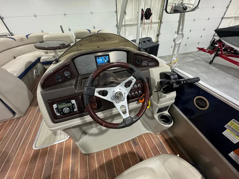 Slide: The Image of Interior view of a 2014 Berkshire 250E STS boat dashboard with steering wheel and controls. - 12