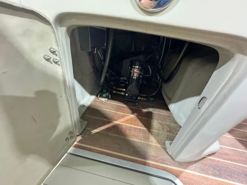 Slide: The Image of Open compartment of a 2014 Berkshire 250E STS boat showing internal wiring and components. - 13