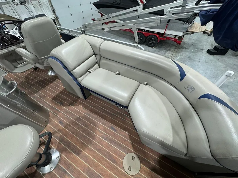 Slide: The Image of 2014 Berkshire 250E STS boat interior with beige seating and wood flooring. - 14