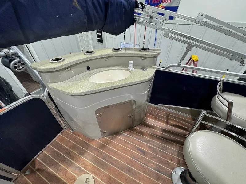 Slide: The Image of Berkshire 250E STS 2014 boat interior with sink and seating on wooden deck. - 16