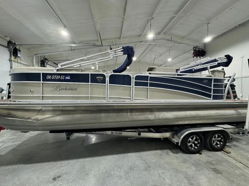 Slide: The Image of 2014 Berkshire 250E STS pontoon boat on trailer in indoor storage facility. - 2