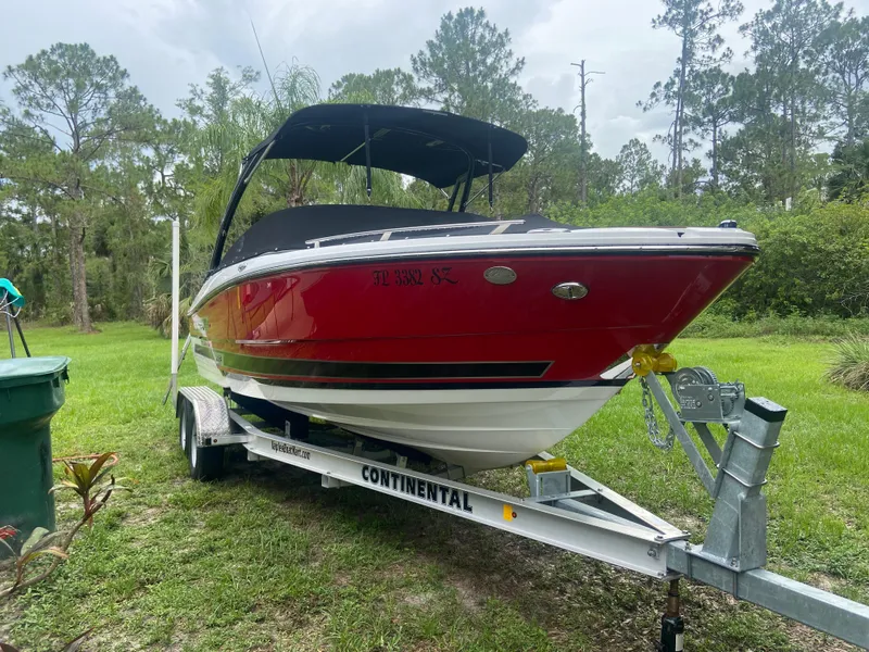 Slide: The Image of Red 2021 Monterey 215 Super Sport boat on trailer in grassy area. - 1