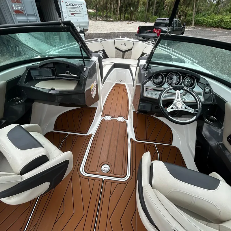 Slide: The Image of 2021 Monterey 215 Super Sport boat interior with sleek dashboard and wood-style flooring. - 10