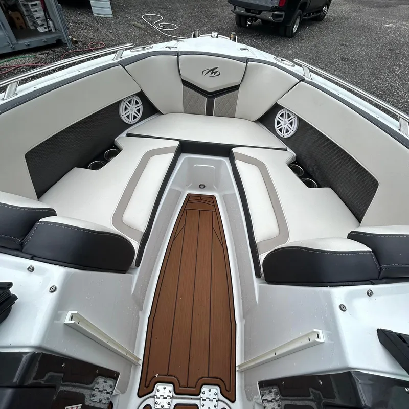 Slide: The Image of 2021 Monterey 215 Super Sport boat interior with cushioned seating and wood accents. - 12