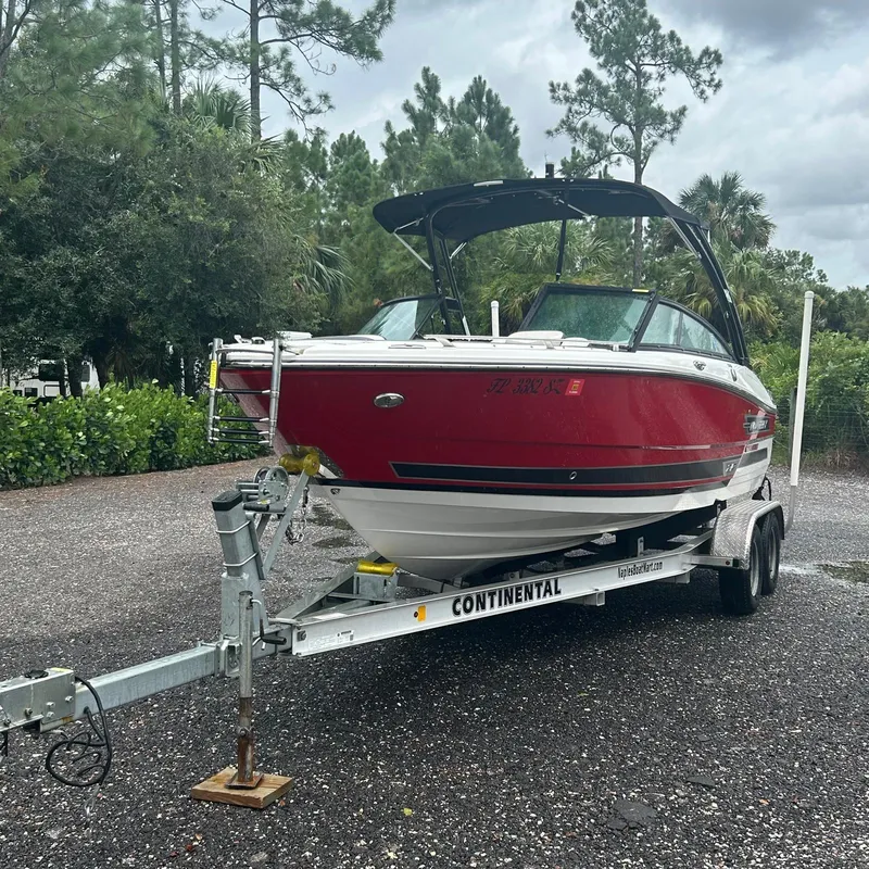 Slide: The Image of Red 2021 Monterey 215 Super Sport boat on trailer, parked outdoors. - 13