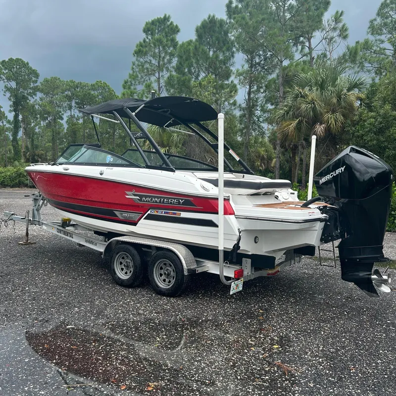Slide: The Image of 2021 Monterey 215 Super Sport boat on trailer, parked outdoors. - 14