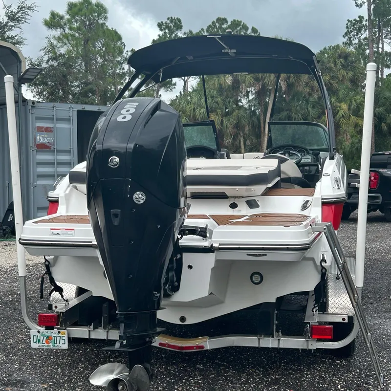 Slide: The Image of 2021 Monterey 215 Super Sport boat with powerful outboard motor, parked outdoors. - 15