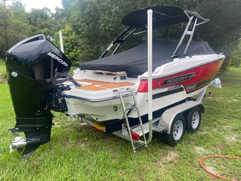 Slide: The Image of 2021 Monterey 215 Super Sport boat on trailer with Mercury outboard engine. - 2