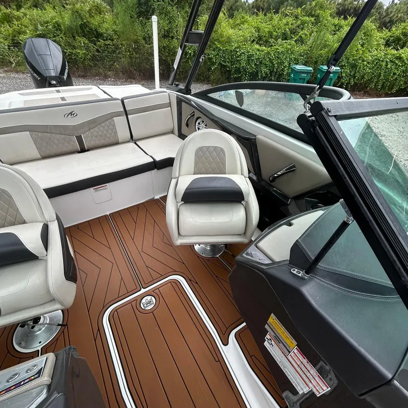 Slide: The Image of 2021 Monterey 215 Super Sport boat interior with plush seating and wood-style flooring. - 5