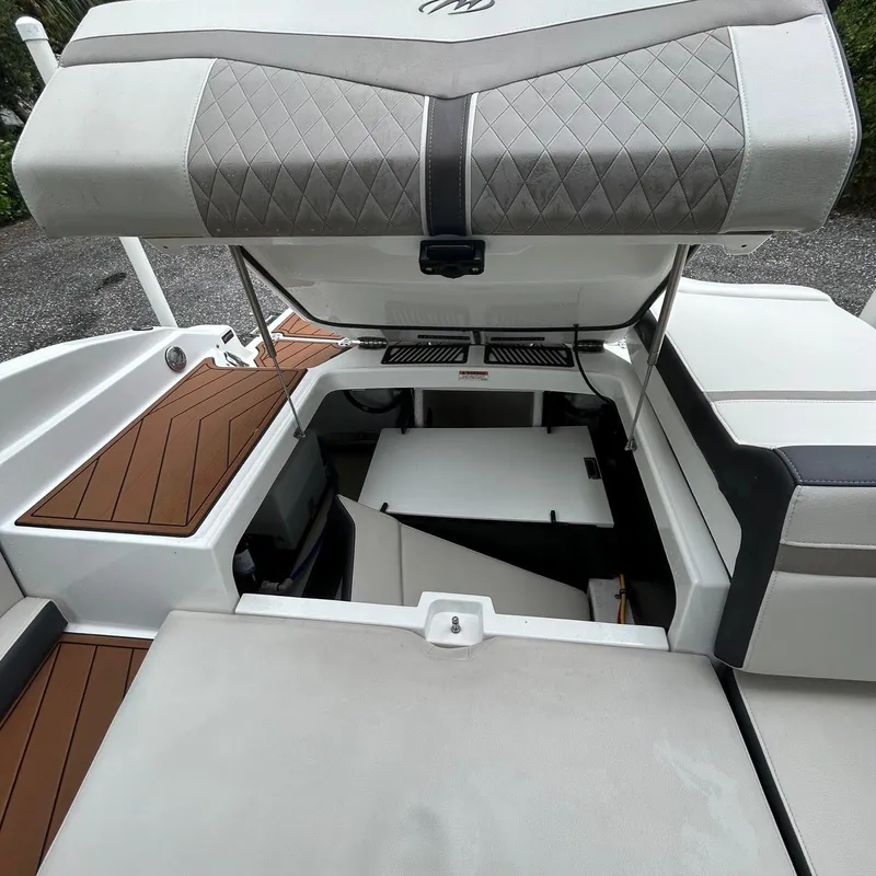 Slide: The Image of 2021 Monterey 215 Super Sport boat interior with open storage compartments. - 7